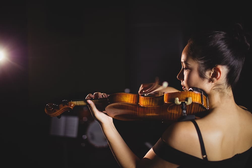 Female Student Playing Violin In A Studio Female Student Playing Violin In A Studio